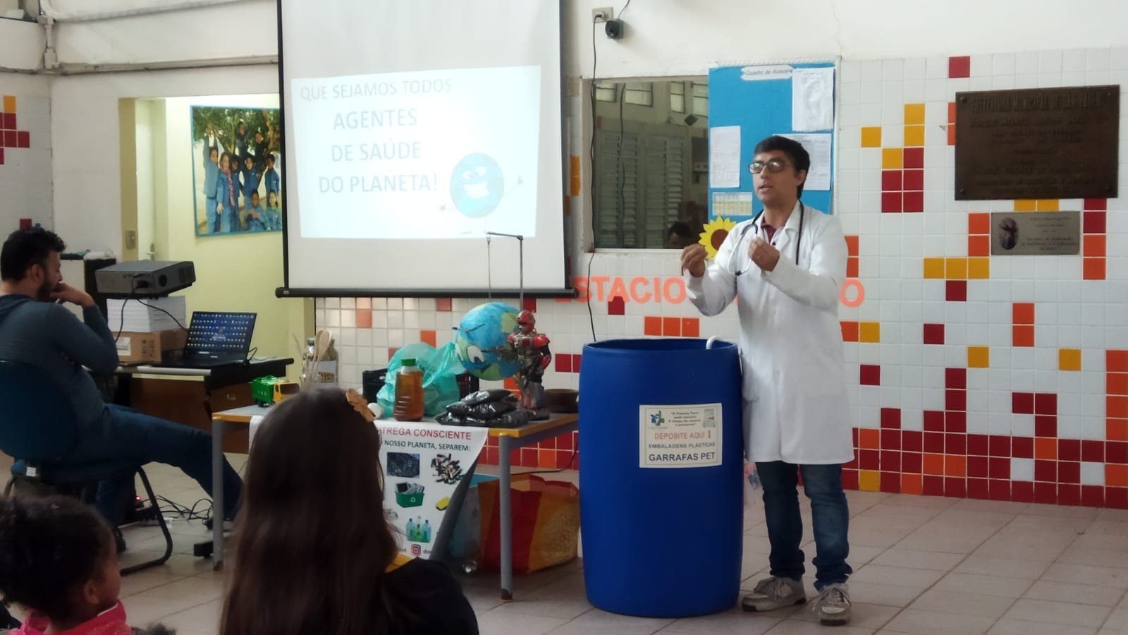 Profissional realizando apresentação sobre reciclagem para uma audiência